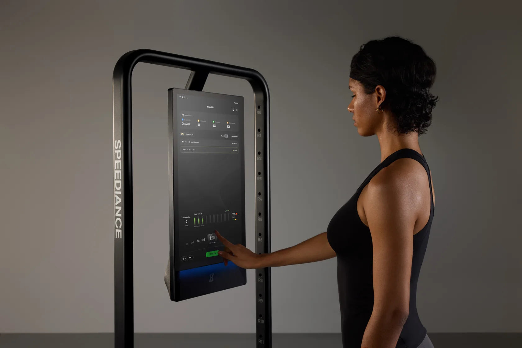 A woman adjusting the digital resistance on the Gym Monster 3 touchscreen